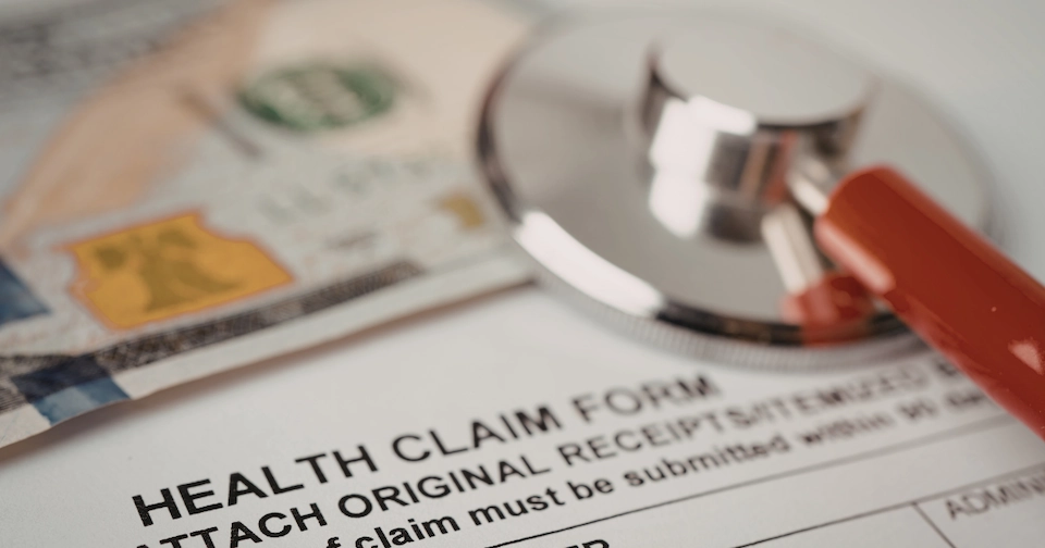 stethoscope on top of a a health claim form